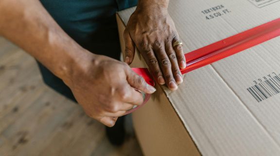 Packed carton of diabetic supplies being taped closed for USPS